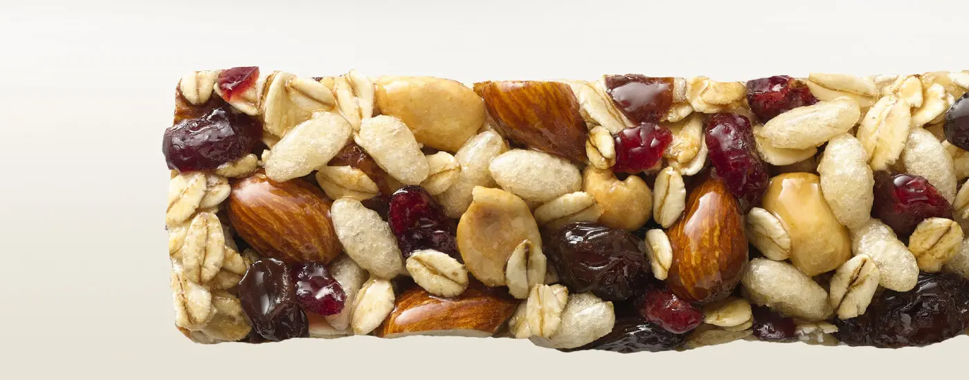 A close-up view of an unwrapped fruit and nut bar.