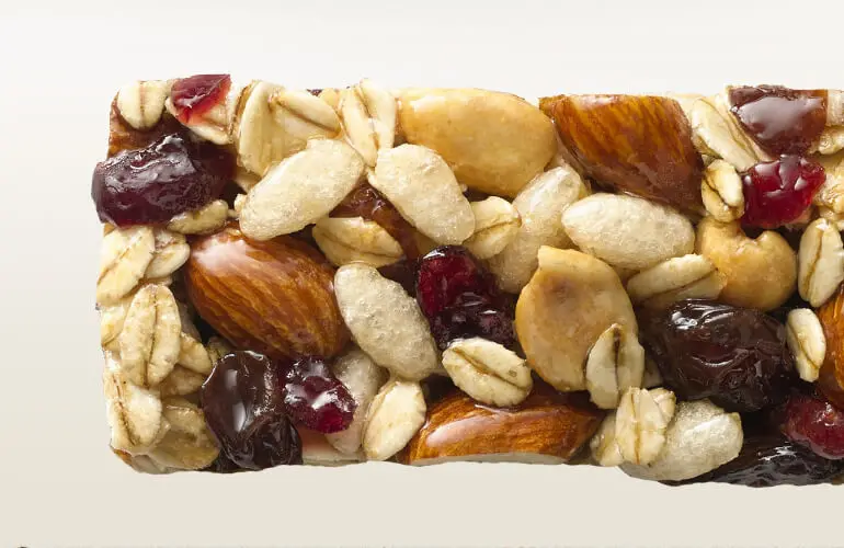 A close-up view of an unwrapped fruit and nut bar.