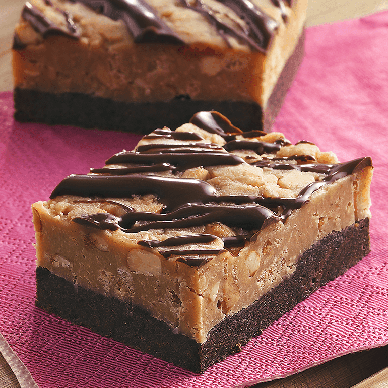Layered chocolate-drizzled no-bake bars made with crushed Nature Valley Peanut Butter Crunchy Granola bars on a fuchsia napkin.