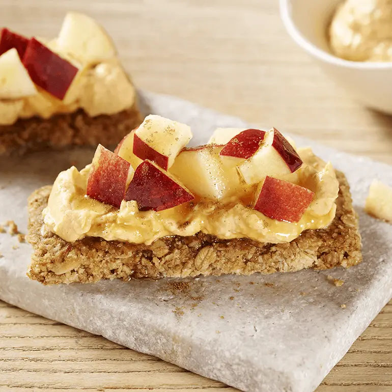 Nature Valley Cinnamon Crunchy Granola Bars spread with pumpkin honey nut cream cheese topped with chopped apple.
