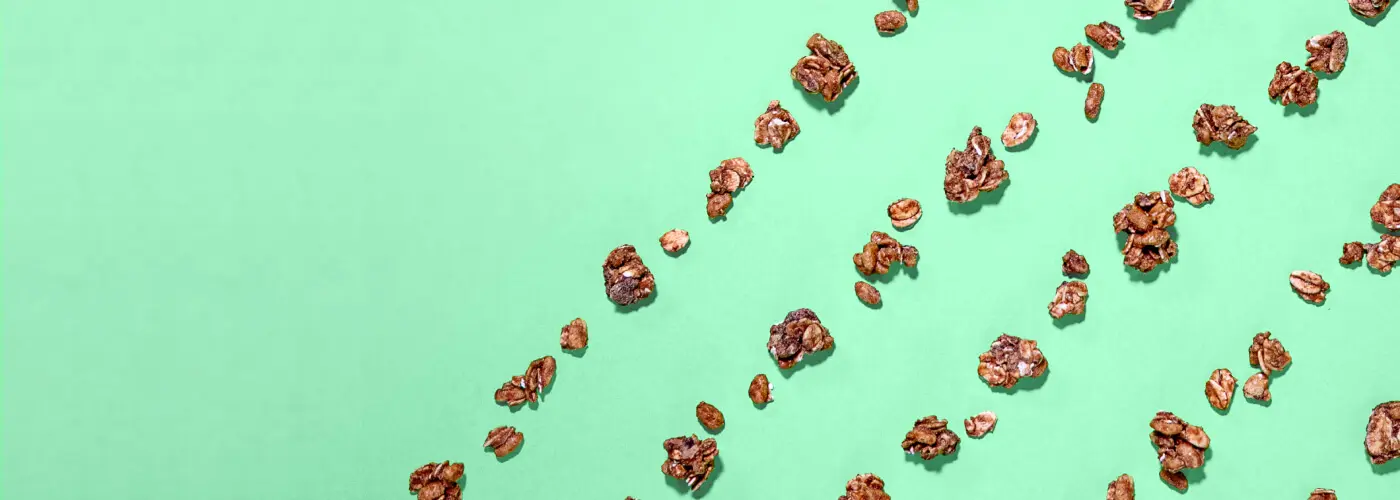 A green background with scattered granola